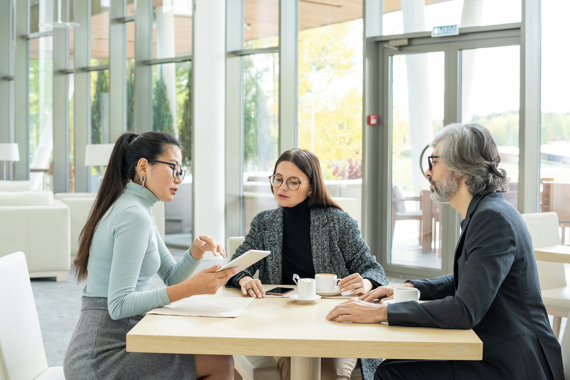 Confident Asian businesswoman in casualwear presenting new plan to colleagues